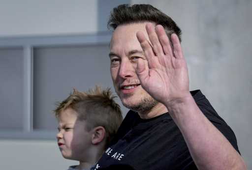 Tesla CEO Elon Musk waves as he leaves the Tesla Gigafactory for electric cars after a visit in Gru…