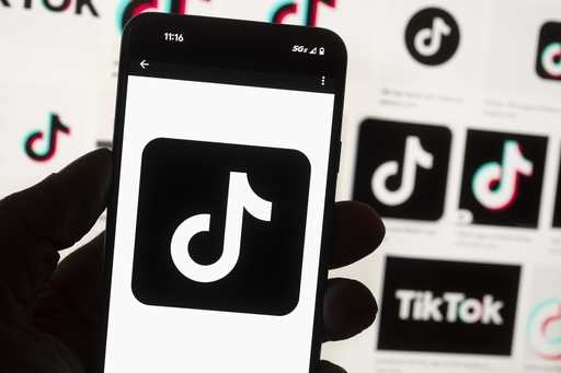 The TikTok logo is displayed on a mobile phone in front of a computer screen, October 14, 2022, in …