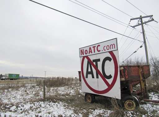 A grain wagon supports a sign against the proposed transmission line by American Transmission Compa…