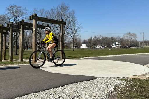 A cyclist rides along the Cardinal Greenway in Muncie, Indiana, March 13, 2024