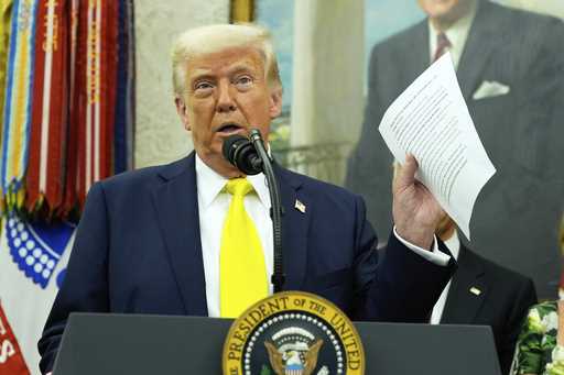 President Donald Trump holds a document with notes about Kilmar Abrego Garcia as he speaks with rep…