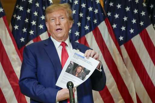 Former President Donald Trump holds up a copy of a story featuring New York Attorney General Letiti…