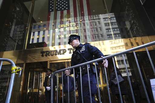 A police officer places a barricade in front of Trump Tower, on Tuesday, March 21, 2023, in New Yor…