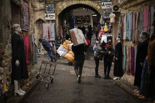 People carry goods in Eminonu trade neighbourhood in Istanbul, Turkey, Wednesday, March 20, 2024
