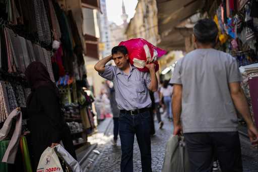 A man carries goods in a street market at Eminonu commercial area in Istanbul, Turkey, Wednesday, J…