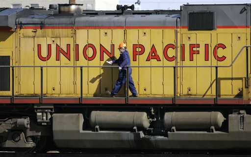 A maintenance worker walks past the company logo on the side of a locomotive in the Union Pacific R…