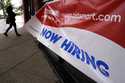 A hiring sign is displayed at a retail store in Downers Grove, Ill