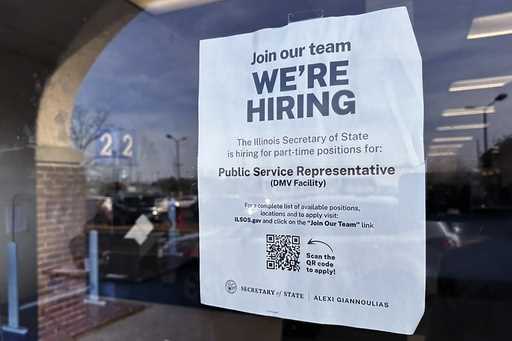 A hiring sign is displayed at the Department of Motor Vehicles office in Deerfield, Ill