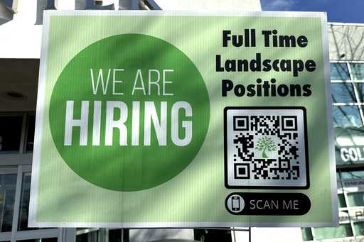 A hiring sign is displayed outside of Golf Center in Des Plaines, Ill