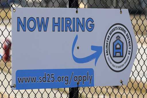 A hiring sign is displayed in Arlington Heights, Ill