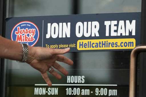 A hiring sign is displayed at a restaurant in Glenview, Ill