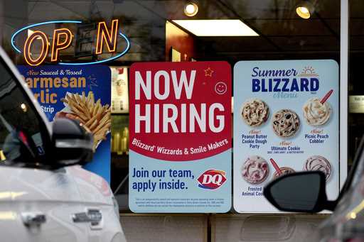 A hiring sign is displayed at a restaurant in Northbrook, Ill
