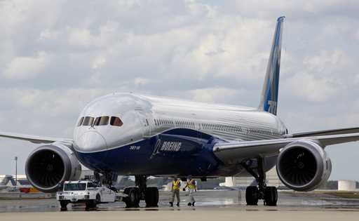 Boeing employees walk the new Boeing 787-10 Dreamliner down towards the delivery ramp area at the c…