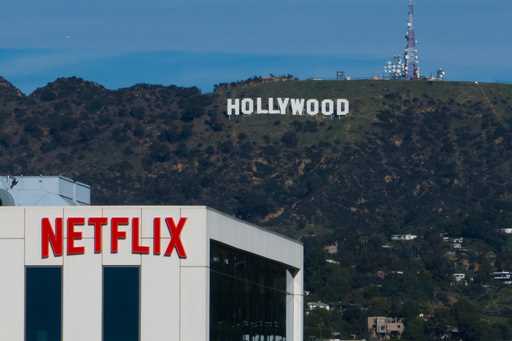 A Netflix sign is displayed atop a building in Los Angeles, on December 18, 2025, with the Hollywoo…