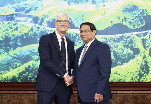 Apple CEO Tim Cook, left, shakes hands with Vietnamese Prime Minister Pham Minh Chinh in Hanoi, Vie…