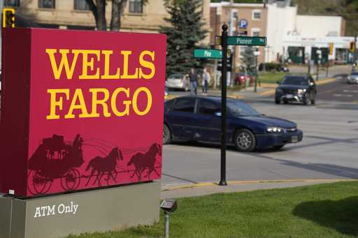 Motorists drive past a sign outside a branch of Wells Fargo bank, Wednesday, Sept