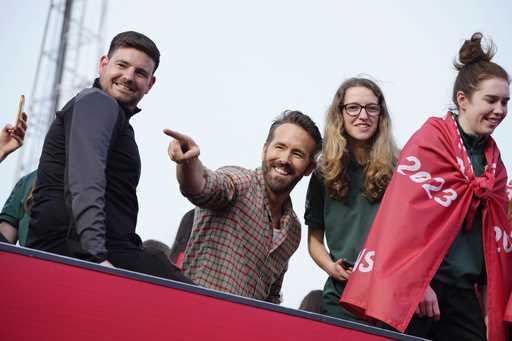 Wrexham co-owner Ryan Reynolds, center, celebrates with members of the Wrexham FC soccer team the p…