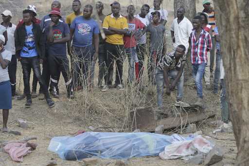 The body of a dead miner lies on the ground wrapped in a plastic sheet after been retrieved from a …