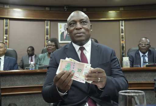 Reserve Bank of Zimbabwe Governor, John Mushayavanhu holds a sample of the country's new currency a…