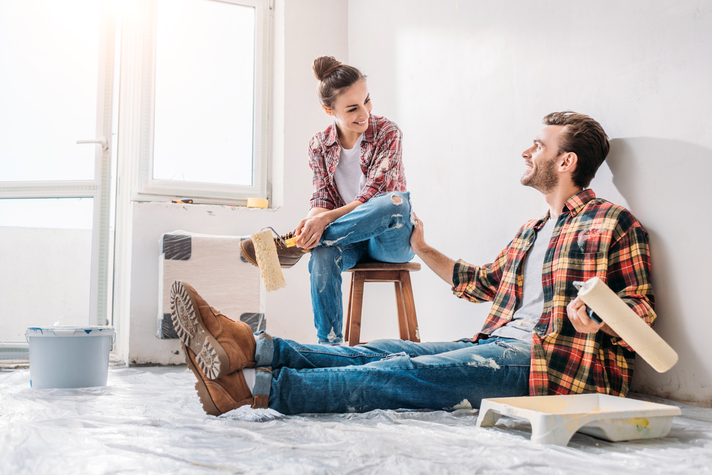 Young couple renovating a home; learn more about home improvement stocks to invest in with MarketBeat