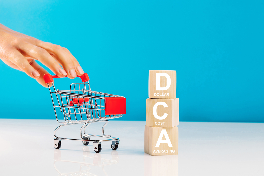 The text DCA written on wooden cubes with woman pushing a stroller. What is dollar cost averaging? Learn more.