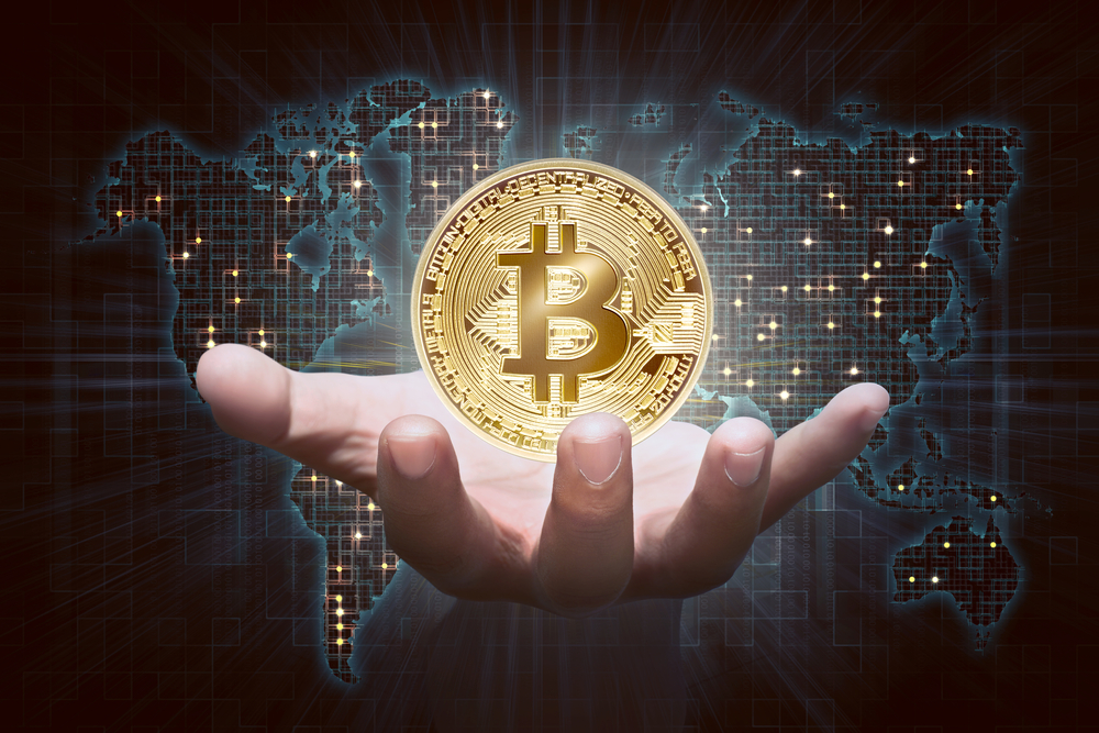 Man hands showing golden bitcoin; what are cryptocurrencies? Learn more.