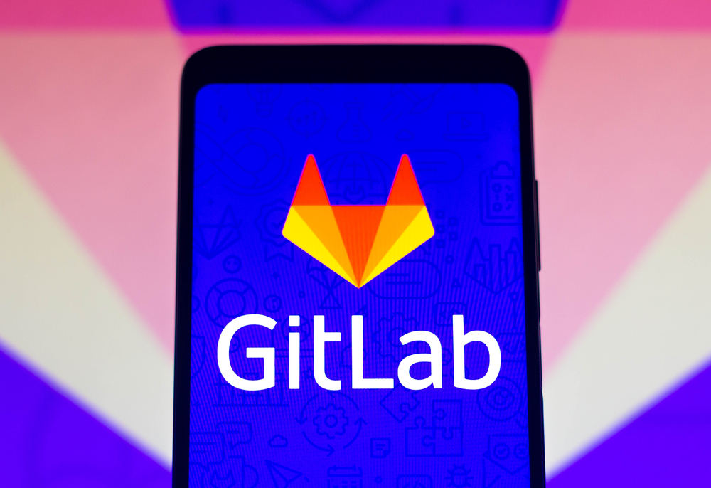 GitLab logo seen displayed on a smartphone and on the background