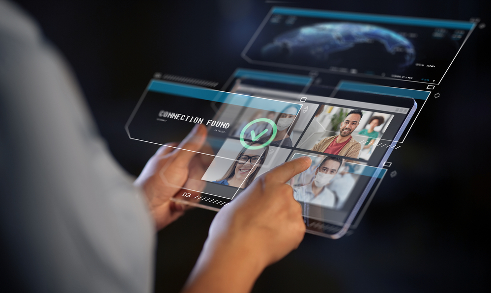 close up of hands with transparent tablet pc computer having video conference with group of people, colleagues or friends on black background