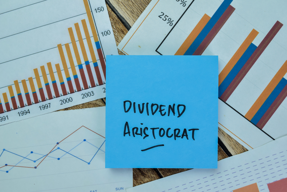 Concept of Dividend Aristocrat write on sticky notes isolated on Wooden Table.
