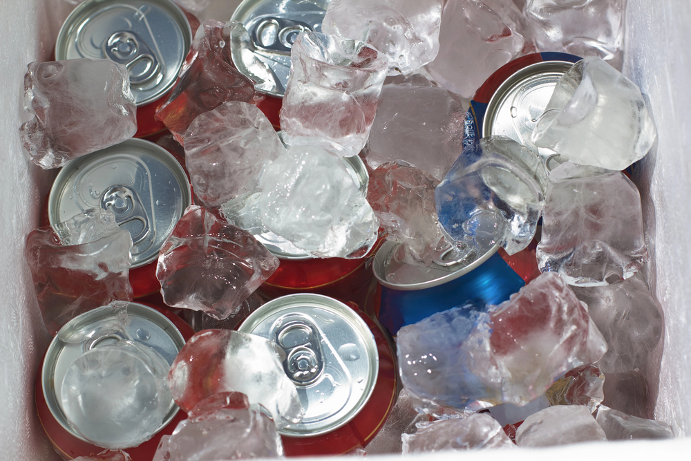 Beverage cans red and blue with ice in a cooler
