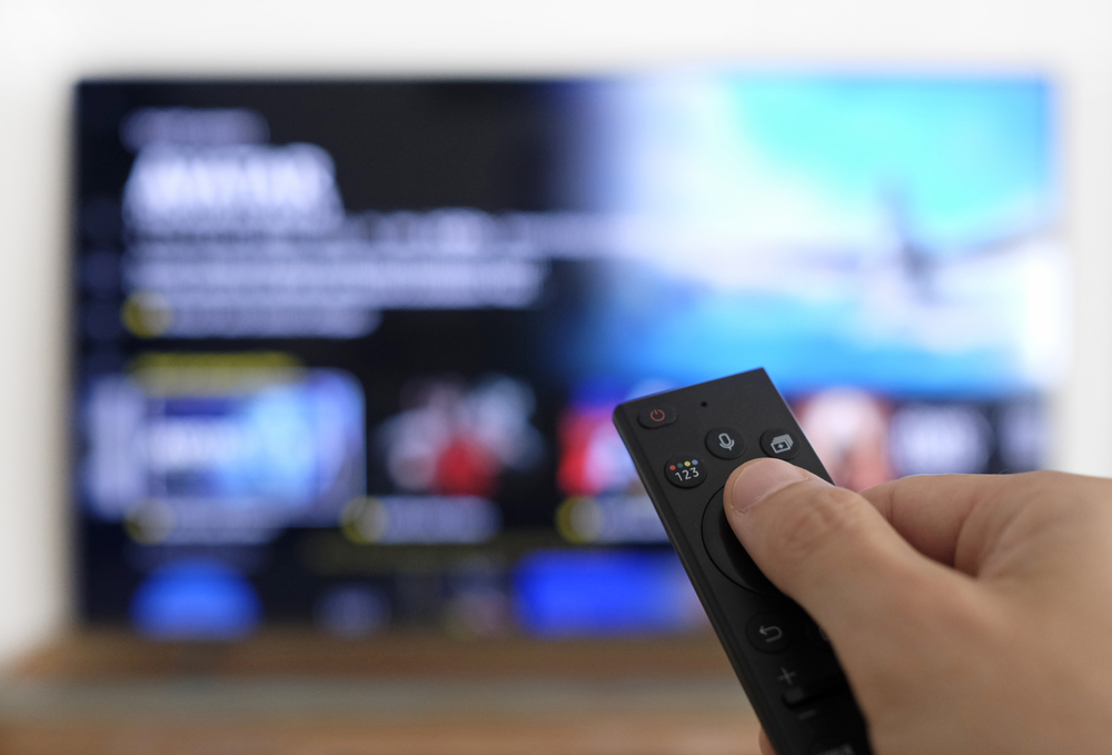 Remote control and screen - watching the favorite TV show