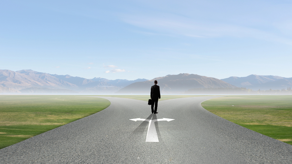 businessman standing at crossroads