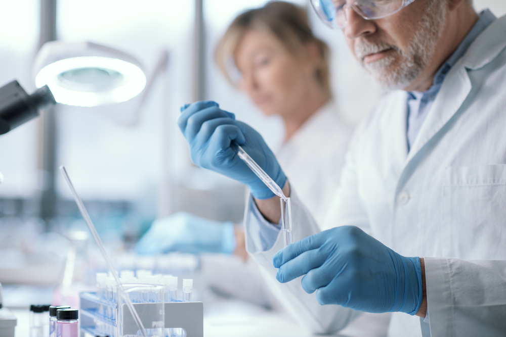 Professional medical researcher working in the laboratory, he is examining samples