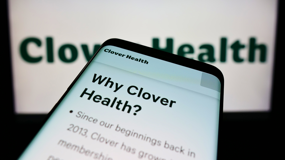 Mobile phone with website of healthcare company Clover Health Investments Corp. on screen in front of logo