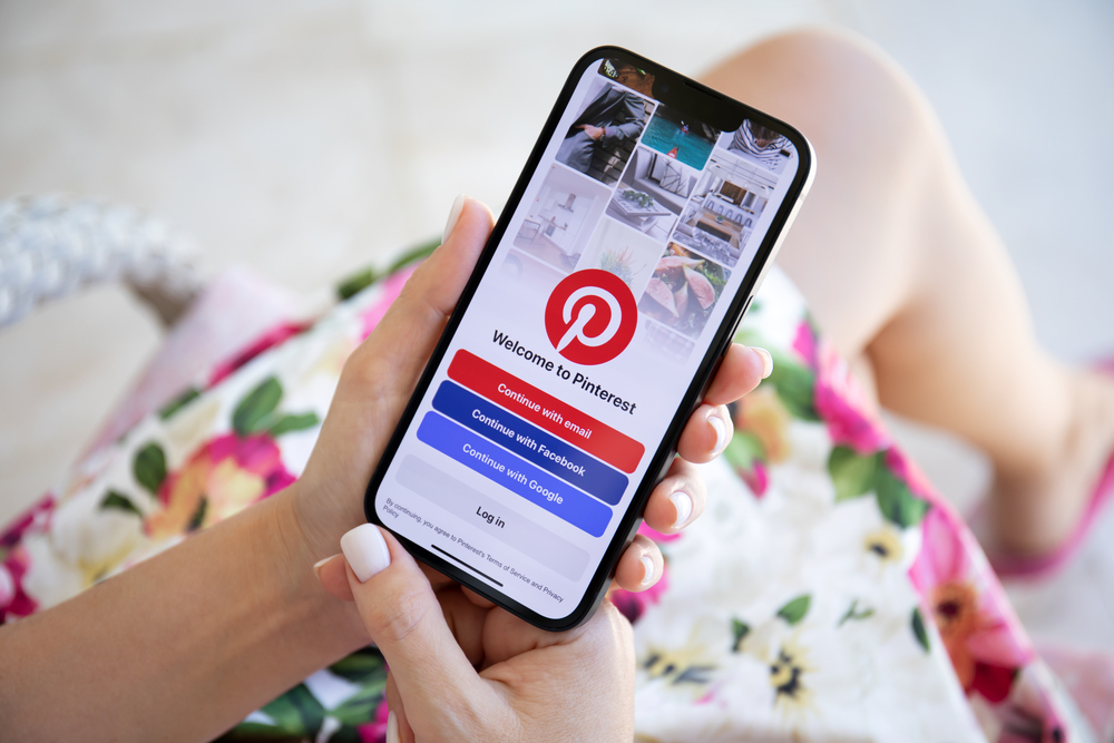Alanya, Turkey - July 27, 2022: Woman hand holding Apple iPhone 13 with app Pinterest in the screen. iPhone 13 was created and developed by the Apple inc.