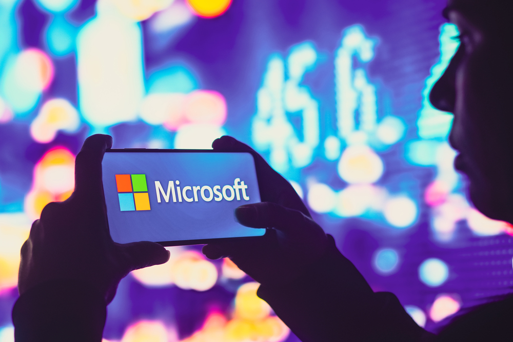 June 1, 2022, Brazil. In this photo illustration, a silhouetted woman holds a smartphone with the Microsoft Corporation logo displayed on the screen