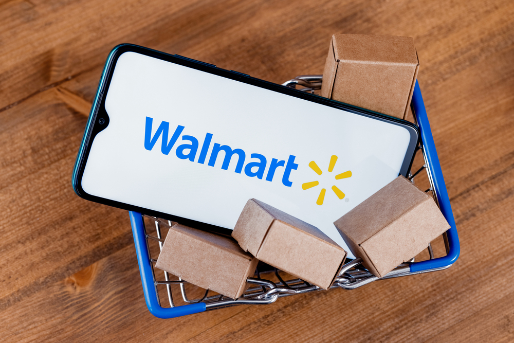Kazan, Russia - Oct 20, 2021: Walmart is an American multinational retail corporation. Smartphone with Walmart logo on the screen, shopping cart and parcels. — Stock Editorial Photography