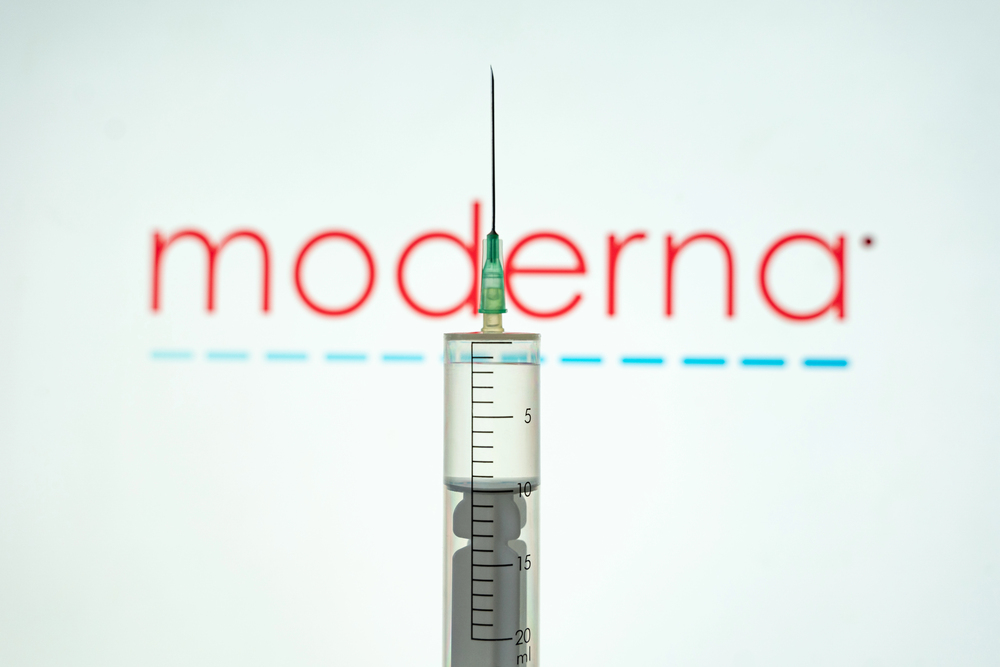 Kyiv, Ukraine April 18, 2021: hand of medical worker with Syringe, Moderna Inc logo in background. The vaccine to fight the coronavirus and Covid-19 pandemic — Stock Editorial Photography