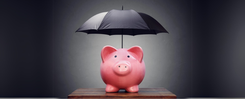 Photo of an umbrella over piggy bank 