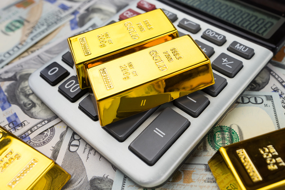 Gold bars lie with a calculator near a large sum of dollars isolated. Concept of financial savings. gold and dollars. — Photo