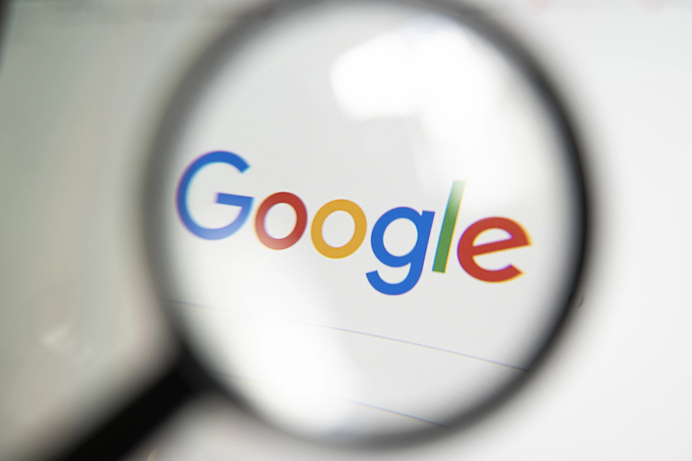 Google logo behind magnifying glass