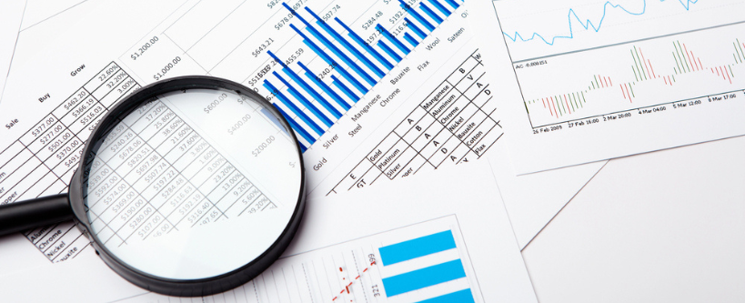 Photo of a magnifying glass over a series of charts