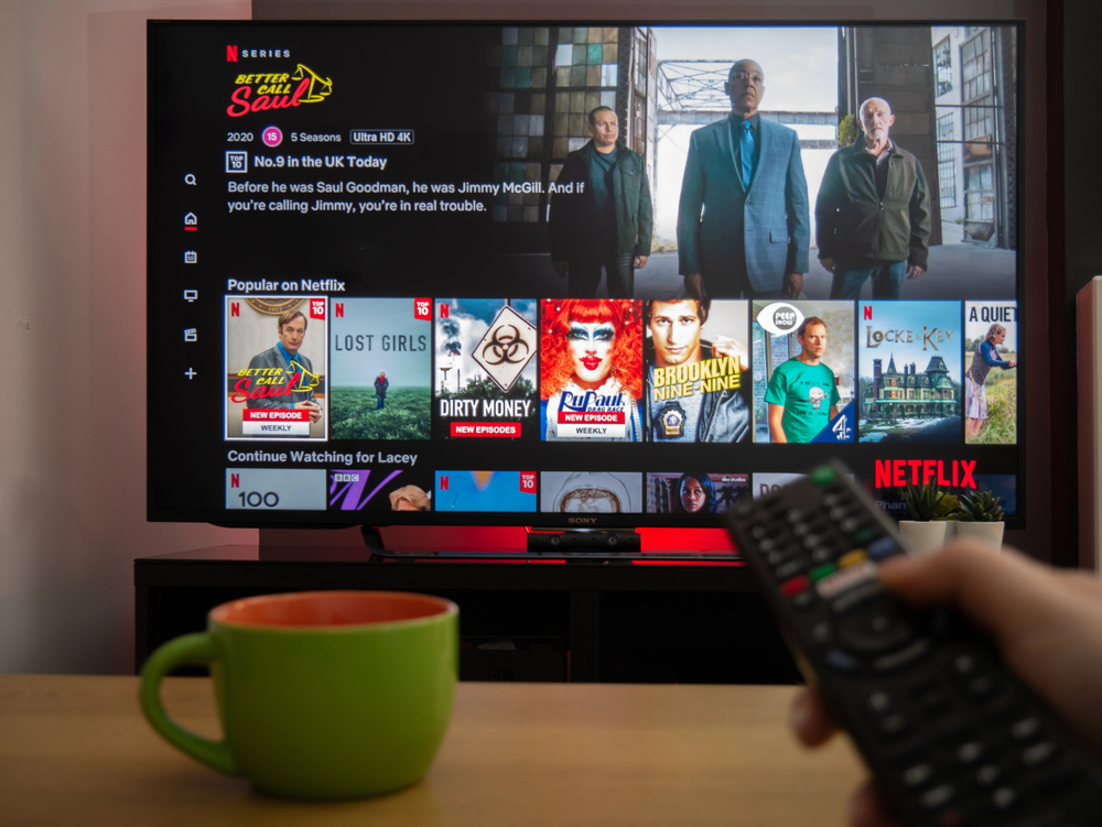 UK, March 2020: TV Television Netlfix menu with remote - Stock Editorial Photography