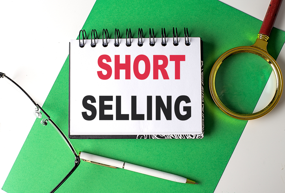 SHORT SELLING text on a notebook on green paper