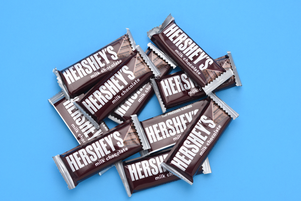 IRIVNE, CALIFORNIA - 3 JULY 2021: A pile of Hersheys Milk Chocolate Snack Size Candy Bars on blue. - Stock Editorial Photography