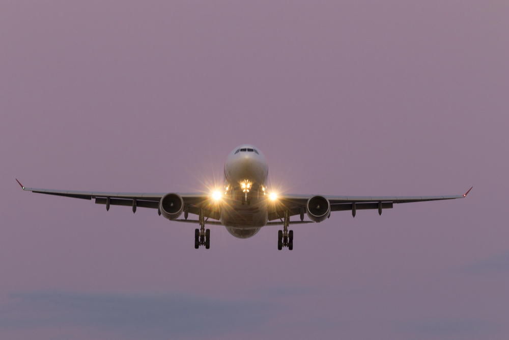 Airplane taking off at the sunset sky