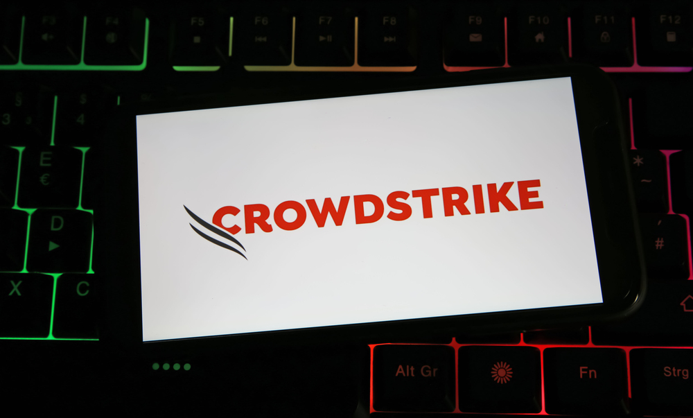 Closeup of mobile phone on computer keyboard with logo lettering of Crowdstrike company