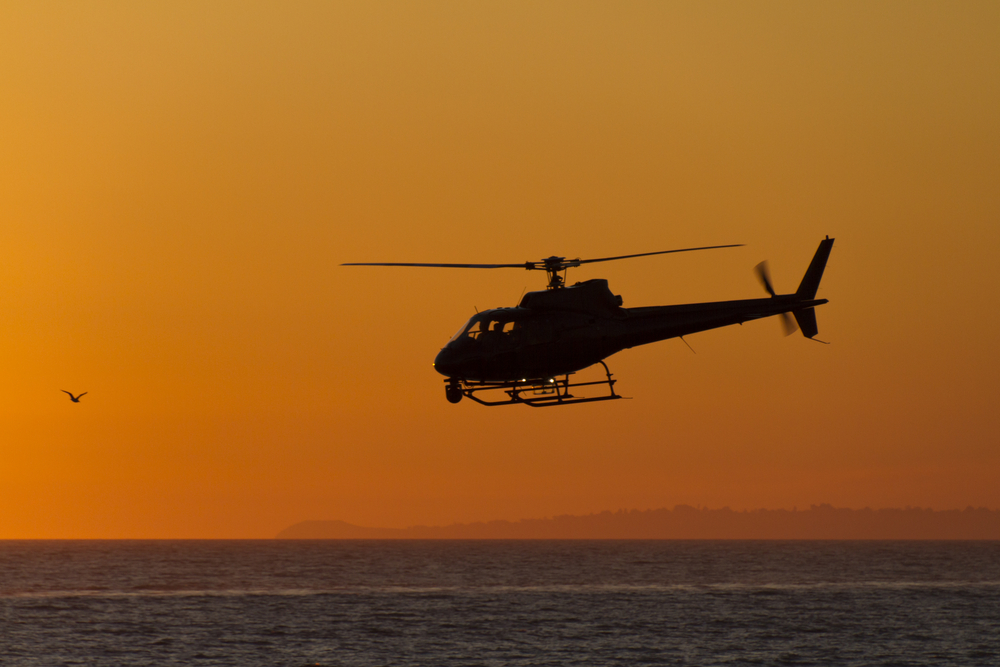 Photo of a helicopter flying at sunset