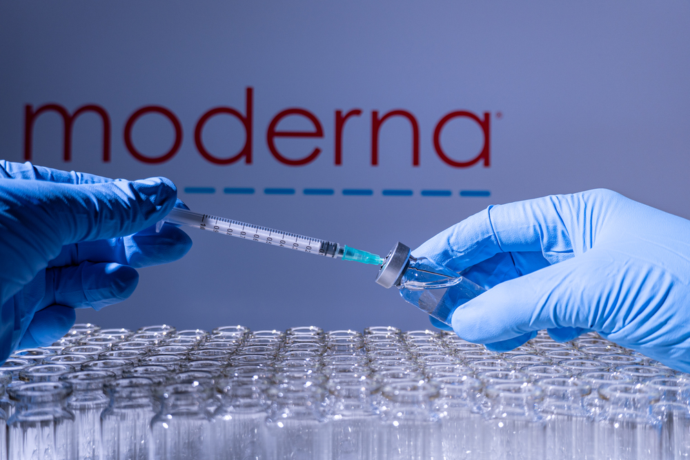 Toronto, Ontario, Canada - February 14, 2021 : A health worker prepares to administer a shot of the American vaccine Moderna. Name is blurry and vials containing messenger RNA technology vaccine.