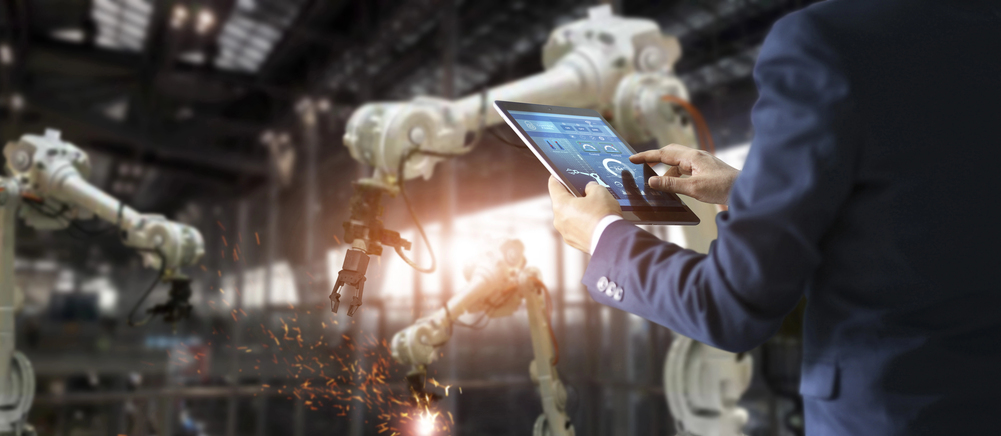 Industrial engineer manager using tablet check and control automatic arms of intelligent factory. — Photo